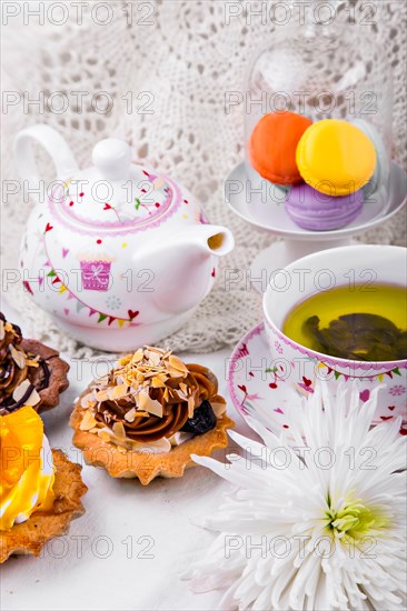 Tasty and delicious cake with a cup of green tea on a white tablecloth