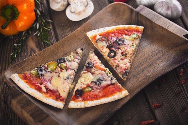 Sliced tasty fresh pizza with mushrooms and sausage on a wooden background. View from above. Close-up