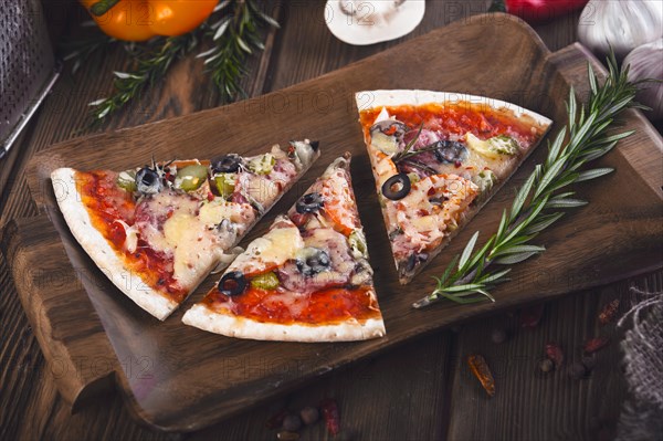 Sliced tasty fresh pizza with mushrooms and sausage on a wooden background. View from above. Close-up