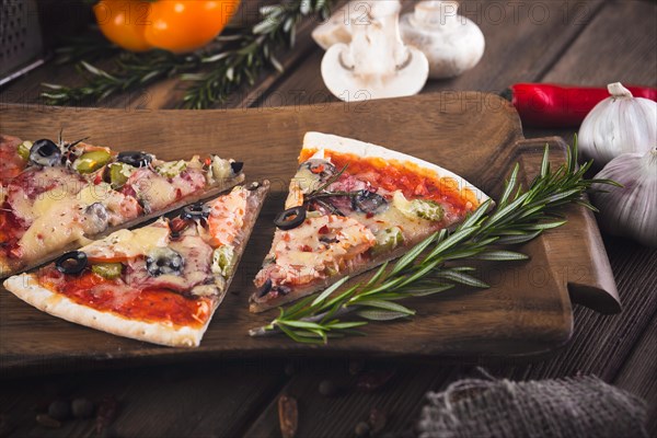 Sliced tasty fresh pizza with mushrooms and sausage on a wooden background. View from above. Close-up