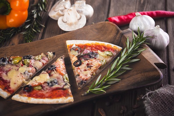 Sliced tasty fresh pizza with mushrooms and sausage on a wooden background. View from above. Close-up