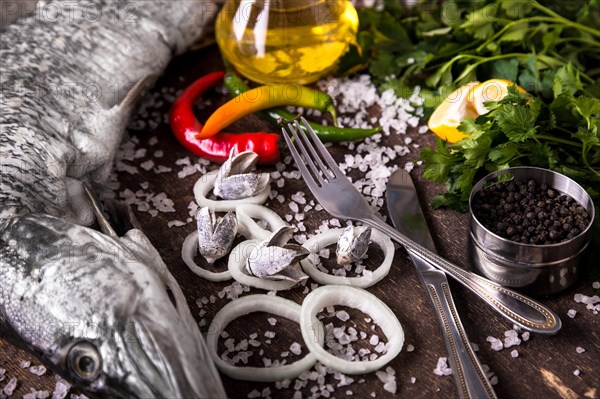 Delicious fresh fish on dark vintage background. Fish with aromatic herbs