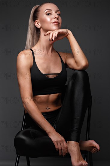 Sports girl with pumped muscles in a tracksuit