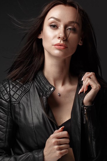 Daring girl model in black leather dress