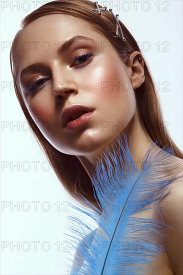 Beautiful tanned girl with creative make-up and blue eyelashes