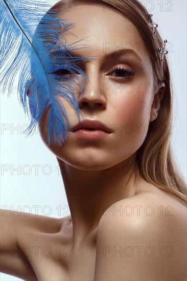 Beautiful tanned girl with creative make-up and blue eyelashes