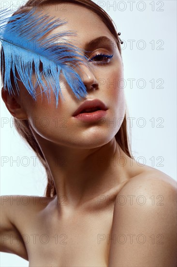 Beautiful tanned girl with creative make-up and blue eyelashes