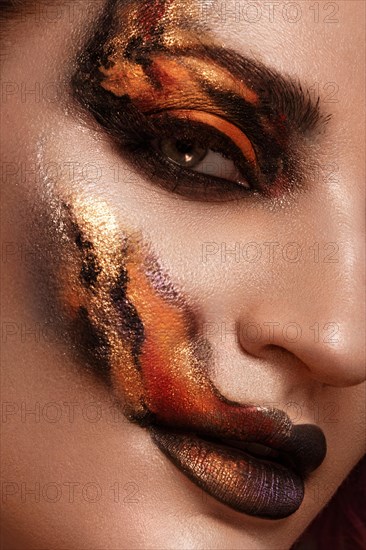 Portrait of a beautiful woman with creative fire art make-up on her face