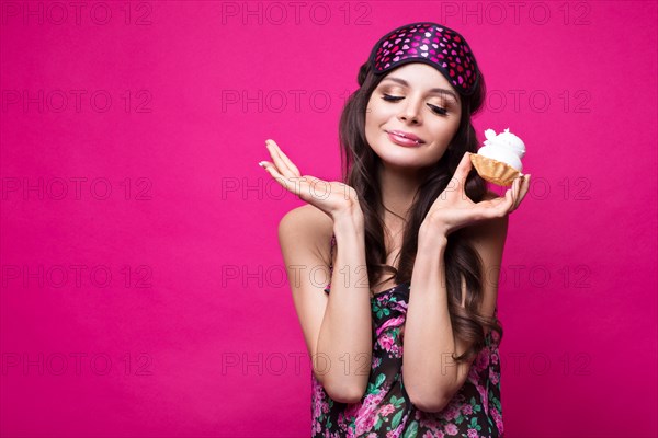 Funny young woman in sleeping mask and pajamas