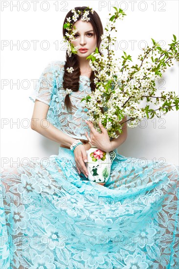 Beautiful brunette girl in blue summer dress with a gentle romantic make-up