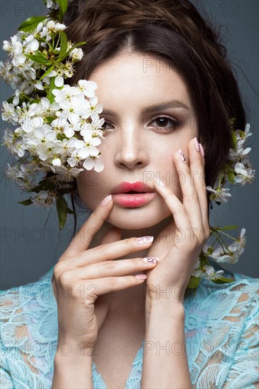 Beautiful brunette girl in blue dress with a gentle romantic make-up
