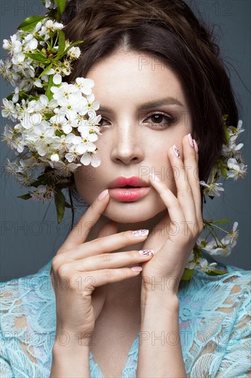 Beautiful brunette girl in blue dress with a gentle romantic make-up