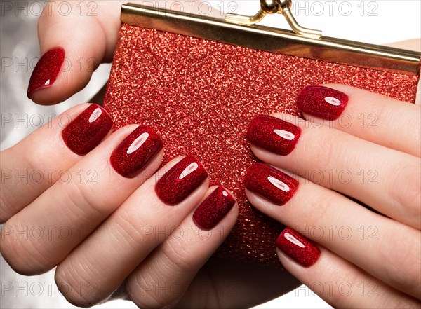 Bright festive red manicure on female hands. Nails design