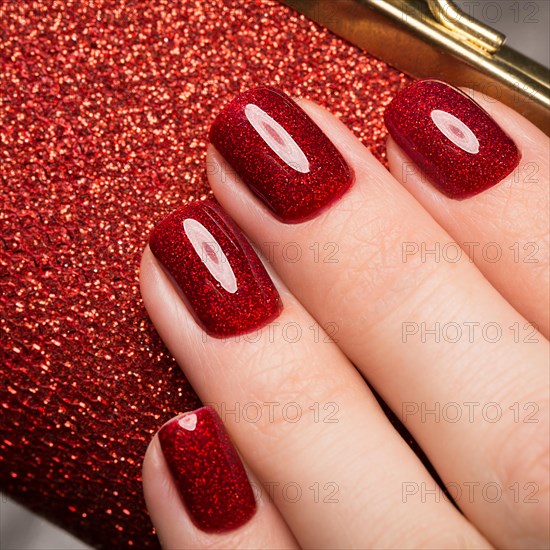 Bright festive red manicure on female hands. Nails design