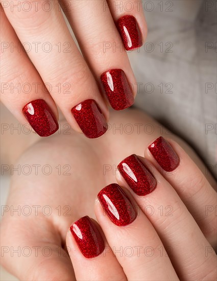 Bright festive red manicure on female hands. Nails design