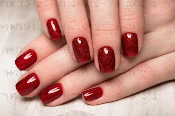 Bright festive red manicure on female hands. Nails design