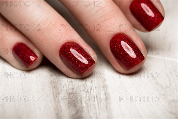 Bright festive red manicure on female hands. Nails design