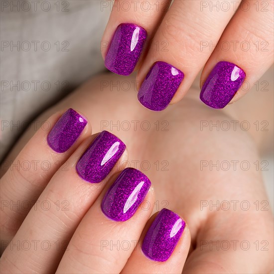 Bright festive purple manicure on female hands. Nails design