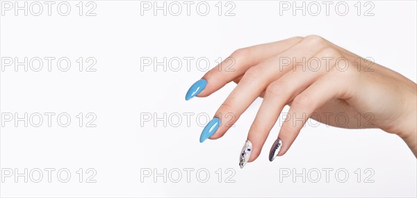 Beautiful summer blue manicure with crystals on female hand. Close-up. Picture taken in the studio