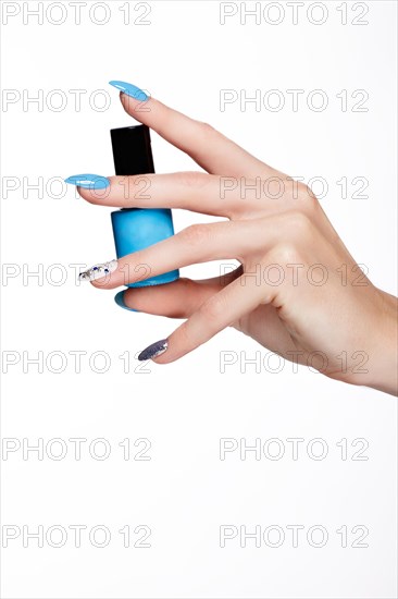 Beautiful summer blue manicure on female hand with nail polish. Close-up. Picture taken in the studio