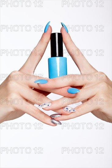 Beautiful summer blue manicure on female hand with nail polish. Close-up. Picture taken in the studio