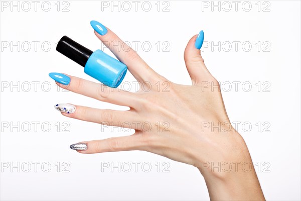 Beautiful summer blue manicure on female hand with nail polish. Close-up. Picture taken in the studio