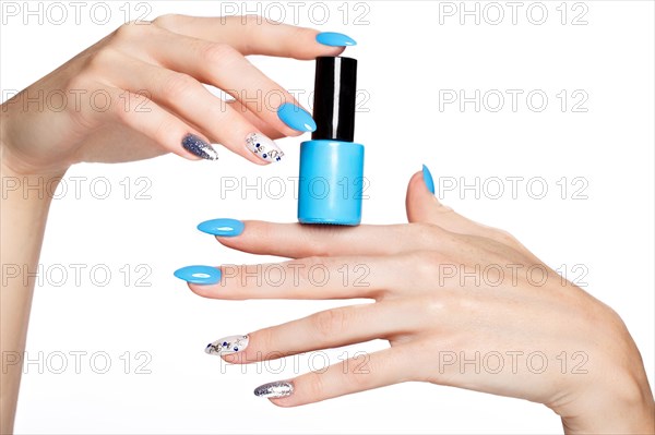 Beautiful summer blue manicure on female hand with nail polish. Close-up. Picture taken in the studio