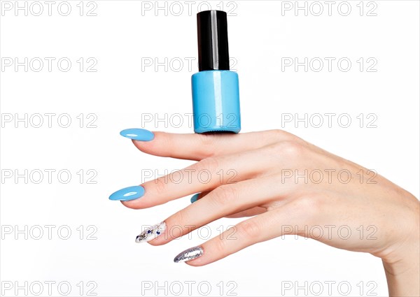 Beautiful summer blue manicure on female hand with nail polish. Close-up. Picture taken in the studio