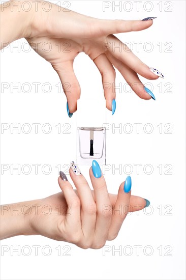 Beautiful summer blue manicure on female hand with oil for cuticles