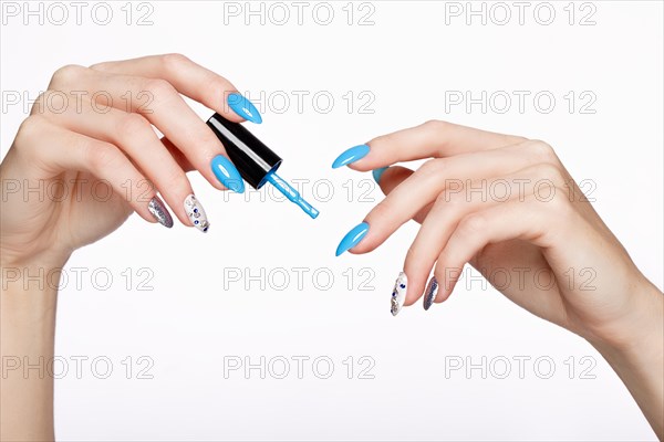 Beautiful summer blue manicure on female hand with nail polish. Close-up. Picture taken in the studio