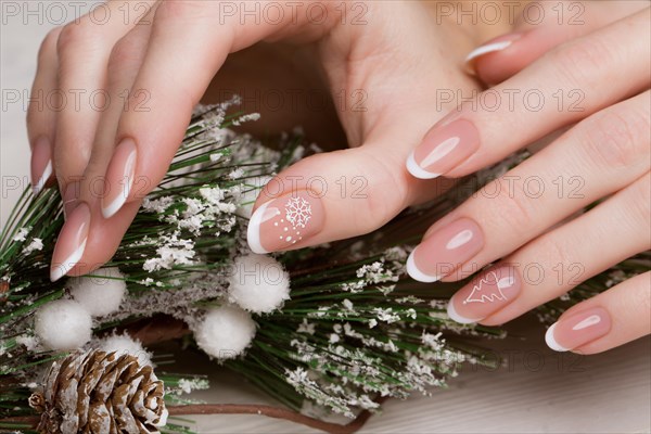 Snow White manicure on female hands. Winter nail design. Picture taken in the studio on a background of wool