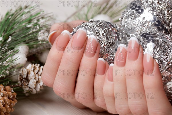 Snow White manicure on female hands. Winter nail design. Picture taken in the studio on a background of wool