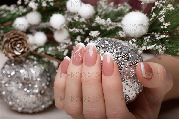 Snow White manicure on female hands. Winter nail design. Picture taken in the studio on a background of wool