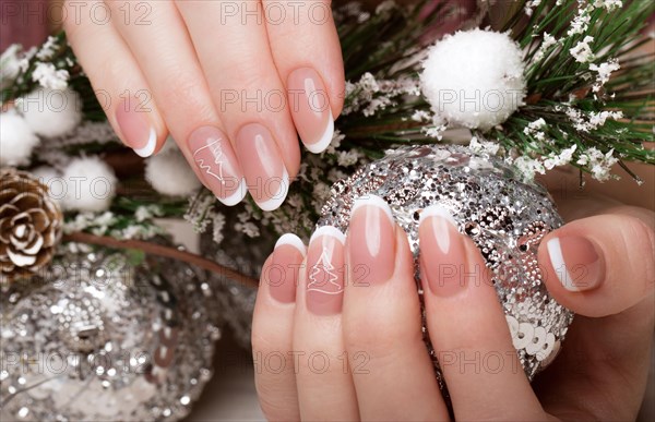 Snow White manicure on female hands. Winter nail design. Picture taken in the studio on a background of wool