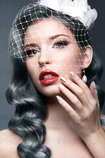 Elegant beautiful girl with silver curls and a veil. Winter image. Beauty face. Picture taken in the studio on a gray background