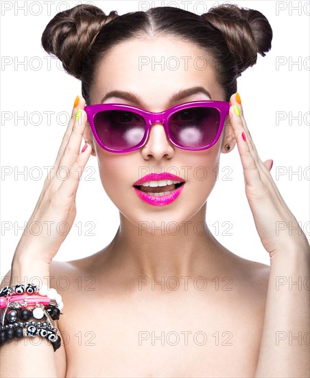 Beautiful girl in pink sunglasses with bright makeup and colorful nails. Beauty face. Picture taken in the studio on a white background