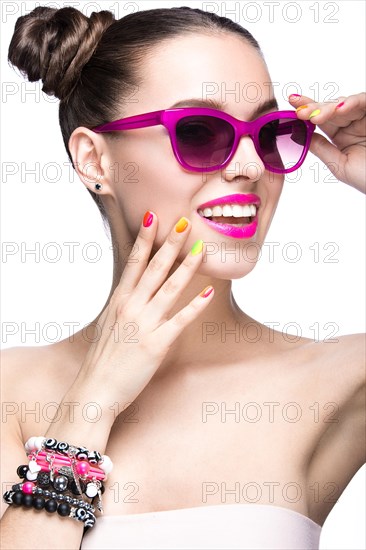 Beautiful girl in pink sunglasses with bright makeup and colorful nails. Beauty face. Picture taken in the studio on a white background