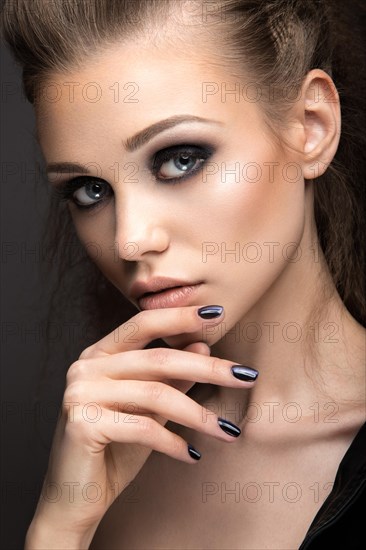 Beautiful girl in leather jacket with bright makeup and manicure Cat's Eye. Beauty face. Nail Design. Picture taken in the studio on a black background