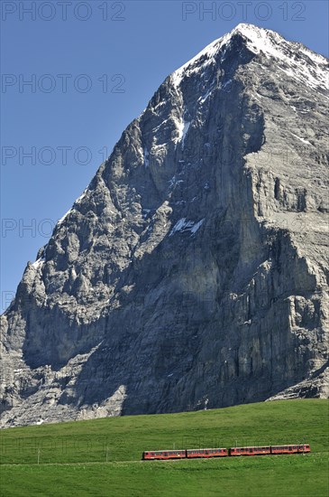 View from the Kleine Scheidegg at the notorious Eiger North Face with typical red train from the Jungfrau Railways in the Bernese Alps