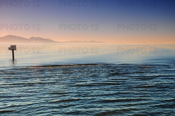 Sea mark at sunset on Lake Constance near Lochau