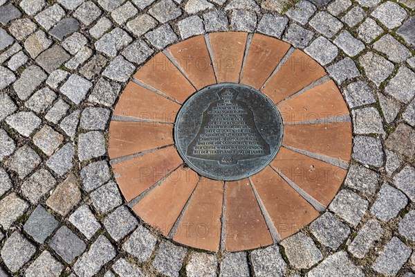 Marker of the bell foundry pit embedded in the ground at the church square