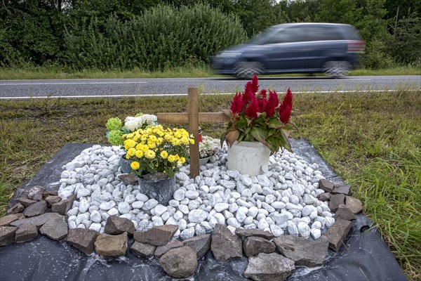 Memorial with cross for victims of road accident on country road