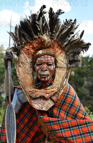 Kikuyu warrior with face paint poses for photographers at Nyahururu Falls