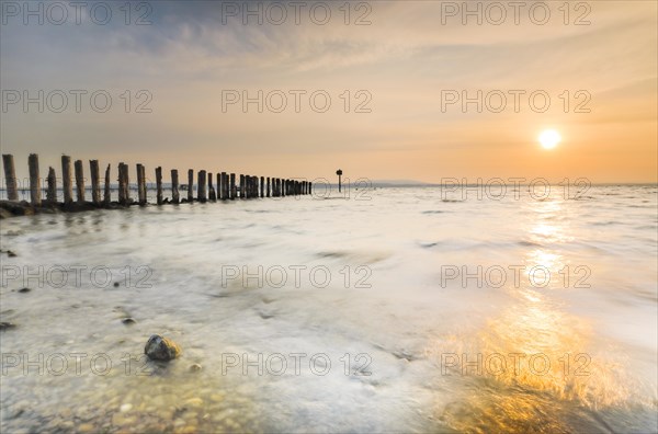 Golden sunrise on the shore of Lake Constance with jetty near Altnau in the canton of Thurgau