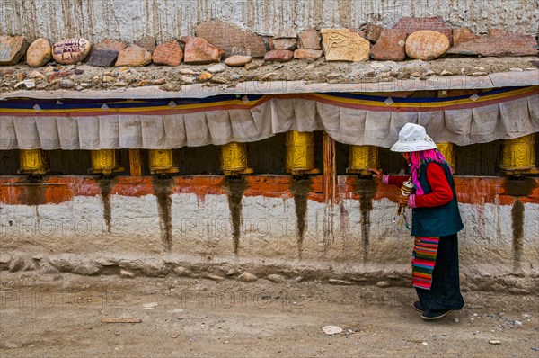 Old woman turning the prayer wheels in the kingdom of Guge