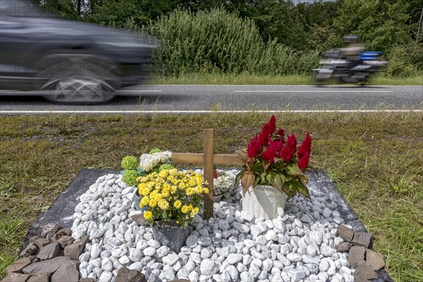 Memorial with cross for victims of road accident on country road