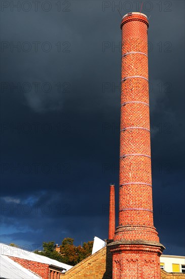 Factory chimney in front of storm clouds