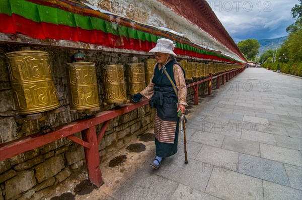 Pigrim with praying wheel before the Potala in Lhasa