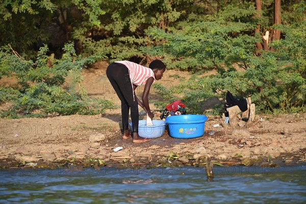Young woman washing clothes at a lake in Kenya