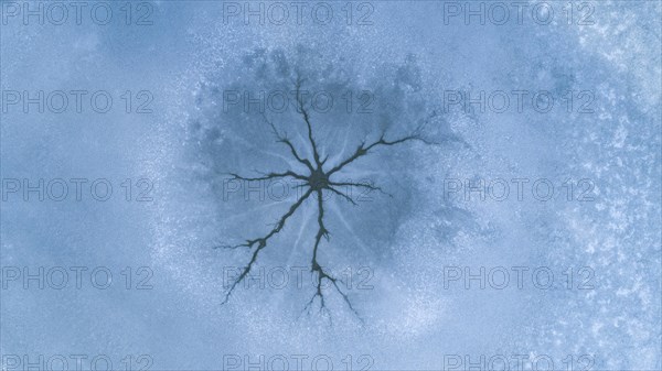 Drone image of so-called steam holes in the ice surface of a frozen lake caused by convection in the water